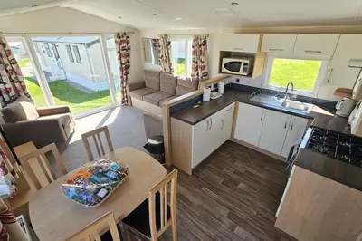 an open kitchen and living room of a caravan at Holiday Home - St Austell in St Austell
