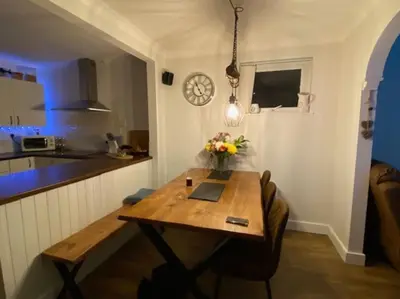 a kitchen with a wooden table with flowers on it at Detached Home Close to the Beach Newquay in Saint Columb Minor