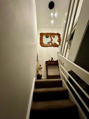 a stairway with a cat sitting on a table at Detached Home Close to the Beach Newquay in Saint Columb Minor