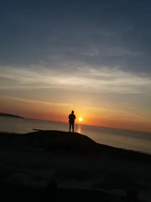 a person standing on top of a beach at sunset at Lanarth Chalet in Hayle Cornwall in Hayle