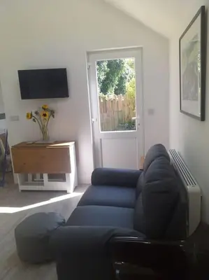 a living room with a blue couch and a television at Lanarth Chalet in Hayle Cornwall in Hayle