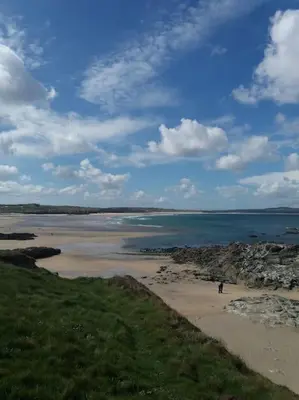 a beach with rocks and the ocean on a cloudy day at Lanarth Chalet in Hayle Cornwall in Hayle