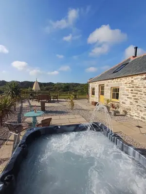a pool with a water feature in front of a building at Luxury countryside retreat with hot tub in Leedstown