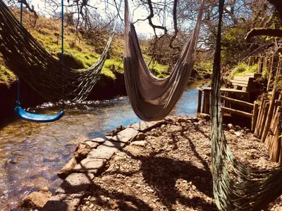 a couple of hammocks hanging over a river at Luxury countryside retreat with hot tub in Leedstown