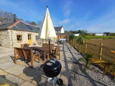 a patio with a table and a white umbrella at Luxury countryside retreat with hot tub in Leedstown