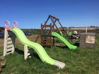 a playground with a slide and a swing at Luxury countryside retreat with hot tub in Leedstown