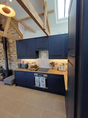a kitchen with blue cabinets and a black refrigerator at Luxury countryside retreat with hot tub in Leedstown
