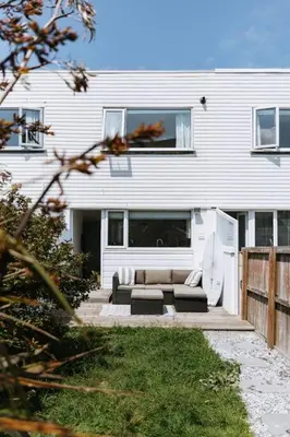 a white house with a couch in front of it at The Surf House Fistral in Newquay