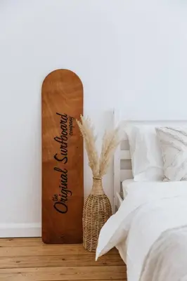 a wooden skateboard standing next to a bedroom with a bed at The Surf House Fistral in Newquay