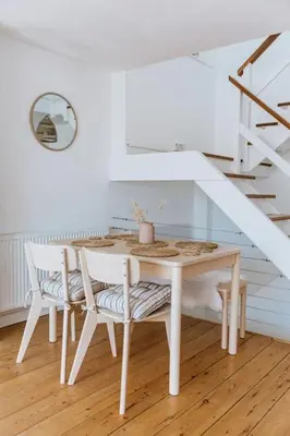 a table and chairs in a room with a staircase at The Surf House Fistral in Newquay