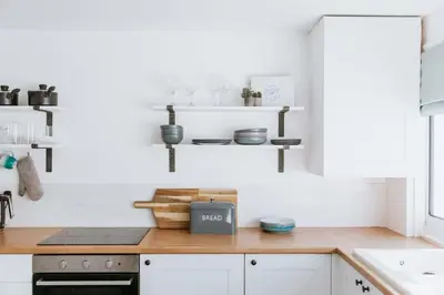 a kitchen with white walls and a wooden counter top at The Surf House Fistral in Newquay
