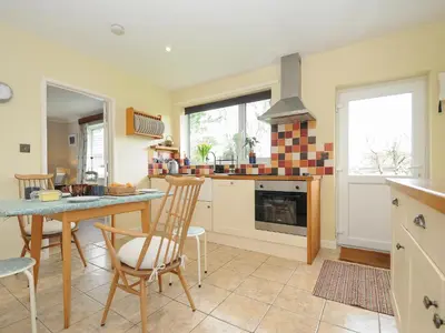 a kitchen with a table and chairs and a stove at Sea Drift in St Austell