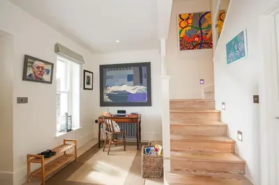 a staircase in a home with white walls and wooden floors at Beachfront home with spectacular sea views in Saint Mawes