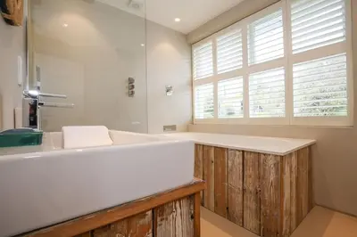 a bathroom with a large white tub and a window at Beachfront home with spectacular sea views in Saint Mawes