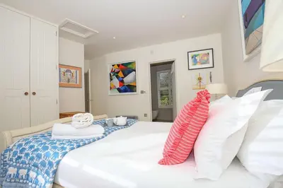 a bedroom with a large white bed with white pillows at Beachfront home with spectacular sea views in Saint Mawes