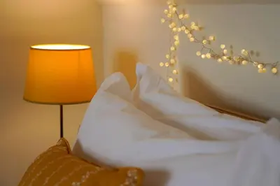 a bedroom with a white bed with a lamp and a lamp at Beachfront home with spectacular sea views in Saint Mawes