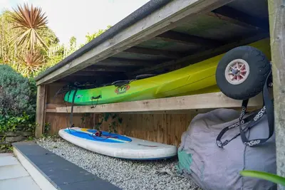 a kayak and a surfboard sitting on top of a building at Beachfront home with spectacular sea views in Saint Mawes