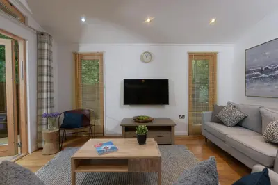 a living room with a couch and a tv at 10 Stonerush Valley in Looe