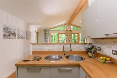 a kitchen with a sink and wooden counter top at 10 Stonerush Valley in Looe