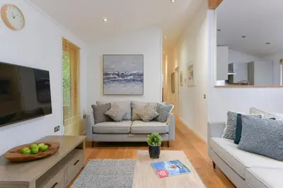 a living room with a couch and a table at 10 Stonerush Valley in Looe