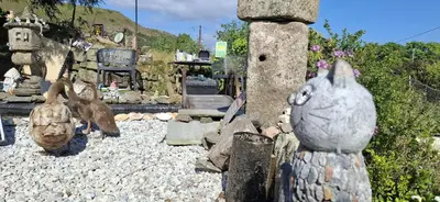 a group of statues of rabbits sitting on a rock yard at Cosy Cornish Cabin in St Austell