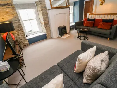 a living room with a couch and a fireplace at Winterbrook Cottage in St Austell