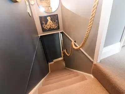 a stairway with a picture of a octopus on the wall at Winterbrook Cottage in St Austell