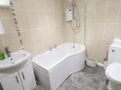 a bathroom with a tub and a sink and a toilet at Winterbrook Cottage in St Austell