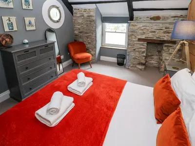 a bedroom with a large bed with towels on it at Winterbrook Cottage in St Austell