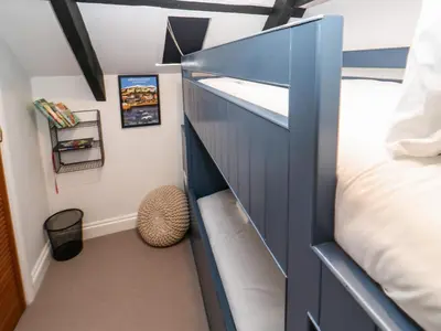 a bedroom with a blue cabinet and a bed at Winterbrook Cottage in St Austell