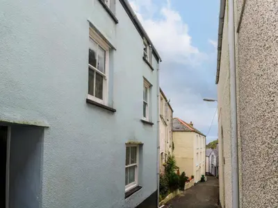 an alley with a blue house and a building at Winterbrook Cottage in St Austell