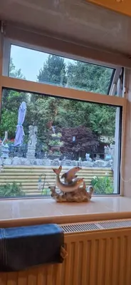 a window with a deer statue sitting on a window sill at Moonraker Room with a View with ensuite shower room in St Austell