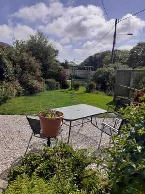 a ping pong table and a potted plant in a garden at Moonraker Room with a View with ensuite shower room in St Austell
