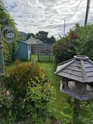 a garden with a bird house in the yard at Moonraker Room with a View with ensuite shower room in St Austell