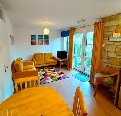 a living room with a couch and a tv at Kerenza Cottage - Families & Pets in Uny Lelant