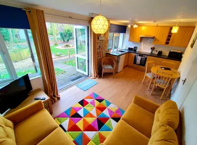 a living room with a couch and a kitchen at Kerenza Cottage - Families & Pets in Uny Lelant