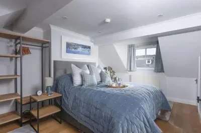 a bedroom with a bed with a blue comforter at 7 Wheal Ayr, St Ives in St Ives