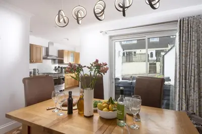 a dining room table with wine bottles and a bowl of fruit at 7 Wheal Ayr, St Ives in St Ives
