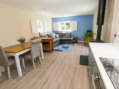 a kitchen and living room with a table and a couch at Chy-An-Oula in Falmouth