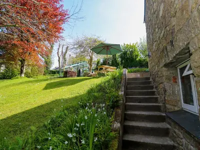 a set of stairs next to a building with an umbrella at Chy-An-Oula in Falmouth