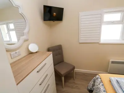 a bedroom with a mirror and a chair at Chy-An-Oula in Falmouth