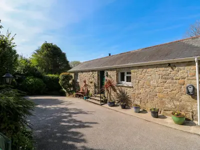 a stone house with potted plants in front of it at Chy-An-Oula in Falmouth