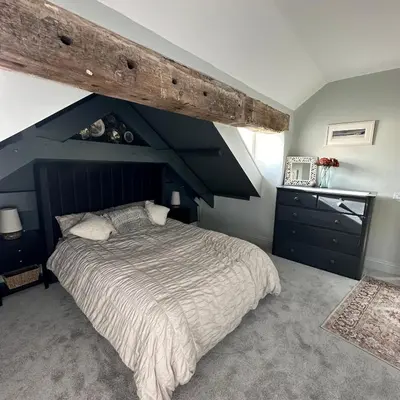 a bedroom with a large bed with a blue ceiling at The Hay Loft in Porkellis