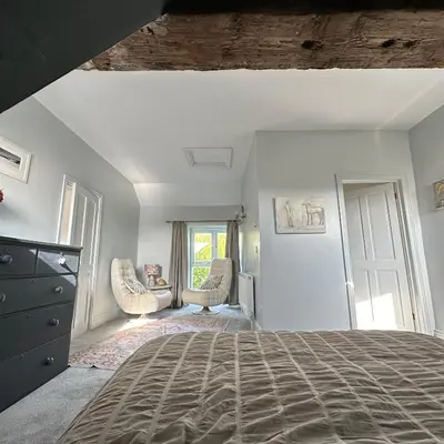 a bedroom with a bed and two chairs at The Hay Loft in Porkellis