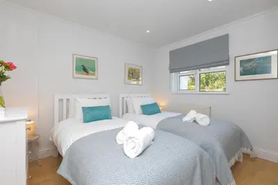 two beds with towels on them in a bedroom at Chy an Pol in St Ives