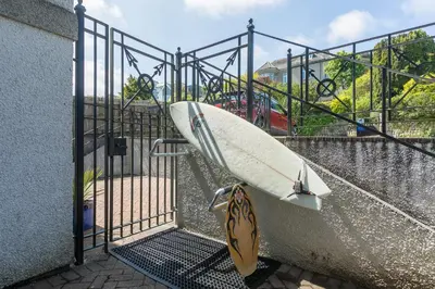 a surfboard is hanging on a metal gate at Chy an Pol in St Ives
