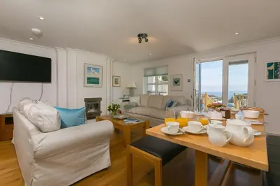 a living room with a table and a couch at Chy an Pol in St Ives