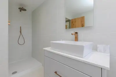a white bathroom with a sink and a tub at Dowran in Hayle
