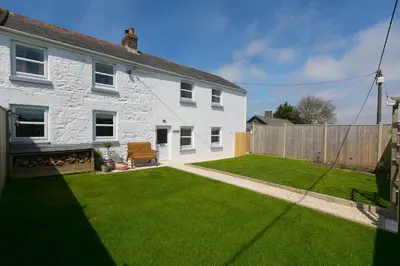 a white house with a yard with green grass at Dowran in Hayle