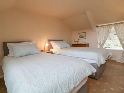 a bedroom with two beds and a window at Lower Tamsquite in Bodmin